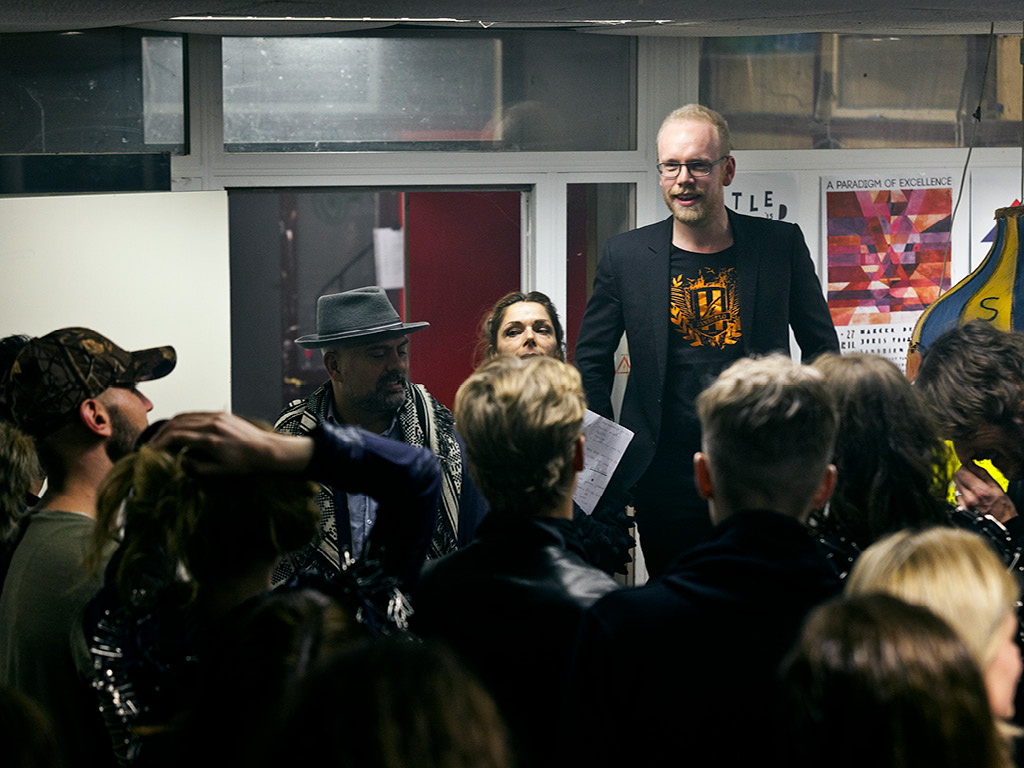 Fashion Designer Jan Boelo at a fashion show talking to his models who are about to go out on the runway