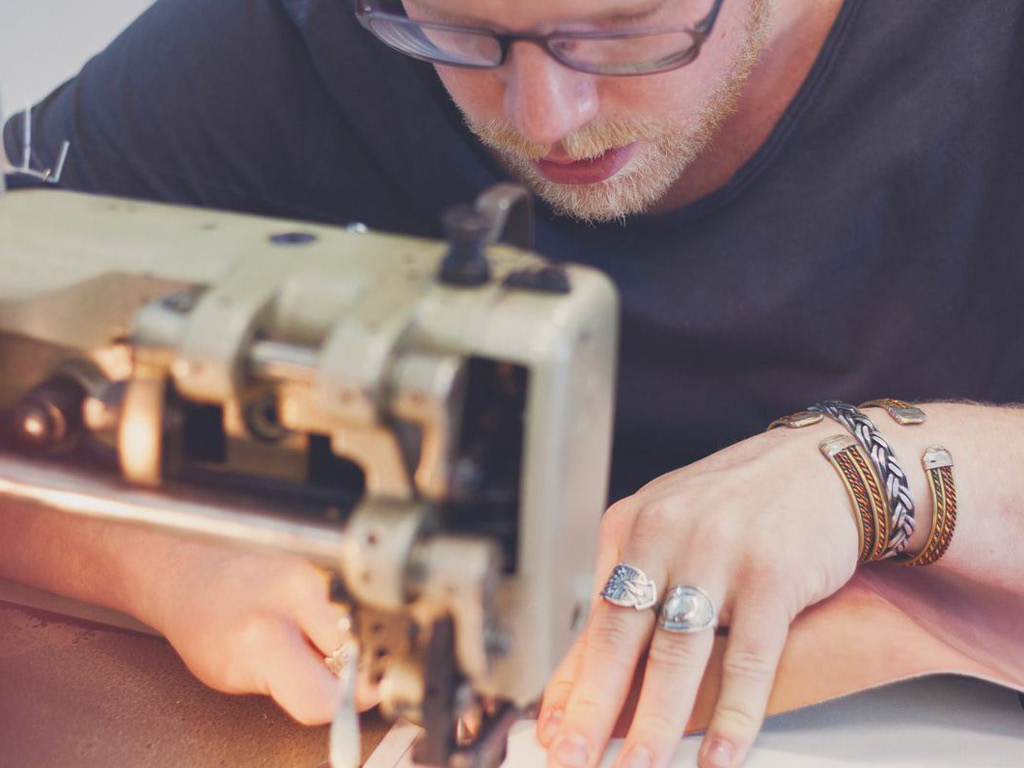 Jan Boelo sitting behind his sewing machine